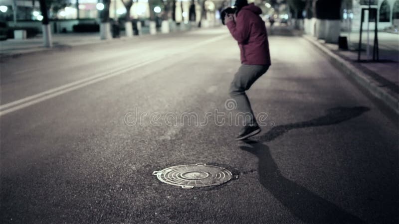 Caminhada engraçada do indivíduo abaixo da cidade da rua da noite, livre