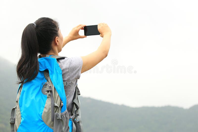 Caminhando a mulher que toma a foto com telefone imagens de stock royalty free Caminhando a mulher que toma a foto com telefone imagens de stock royalty free