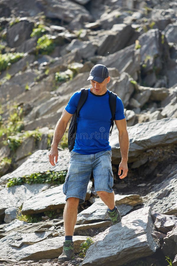 Caminhante com a trouxa nas montanhas imagem de stock royalty free