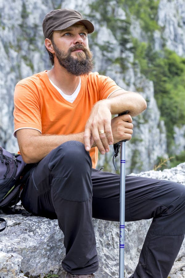 Caminhante novo que descansa na parte superior da montanha imagem de stock Caminhante novo que descansa na parte superior da montanha imagem de stock