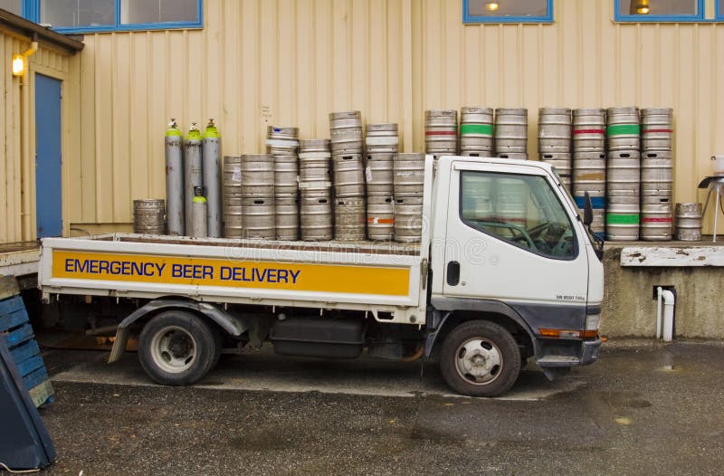Emergency beer delivery truck surrounded by empty beer kegs. Emergency beer delivery truck surrounded by empty beer kegs.