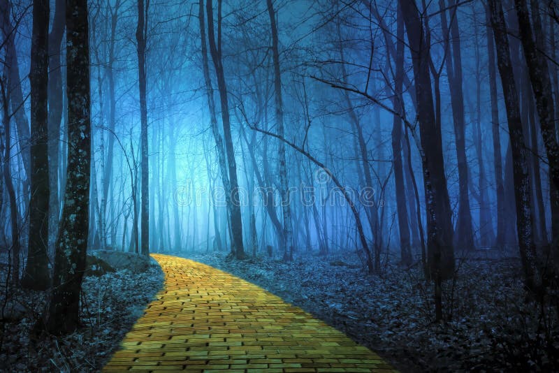 Camino amarillo del ladrillo que lleva a través de un bosque fantasmagórico imagen de archivo
