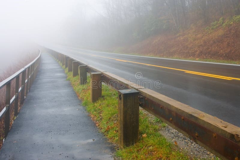 Foggy road leading off into the distance in the mountains. Foggy road leading off into the distance in the mountains