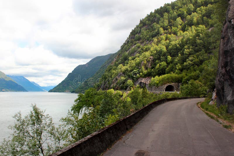 Camino costero a lo largo de las orillas rocosas del fiordo de Hardanger, Noruega imagen de archivo libre de regalías Camino costero a lo largo de las orillas rocosas del fiordo de Hardanger, Noruega imagen de archivo libre de regalías