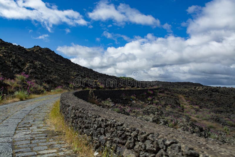 Camino de piedra a través de campos de lava negros en las cuestas del volcán del monte Etna, acceso del coche al parque nacional imagenes de archivo Camino de piedra a través de campos de lava negros en las cuestas del volcán del monte Etna, acceso del coche al parque nacional imagenes de archivo