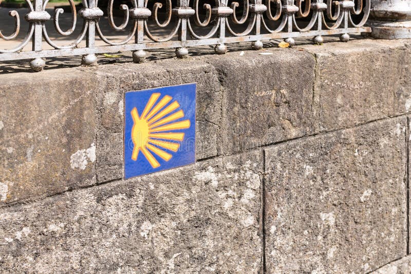 Camino de Santiago sign tile on stone wall. Way of St. James way shell royalty free stock photo