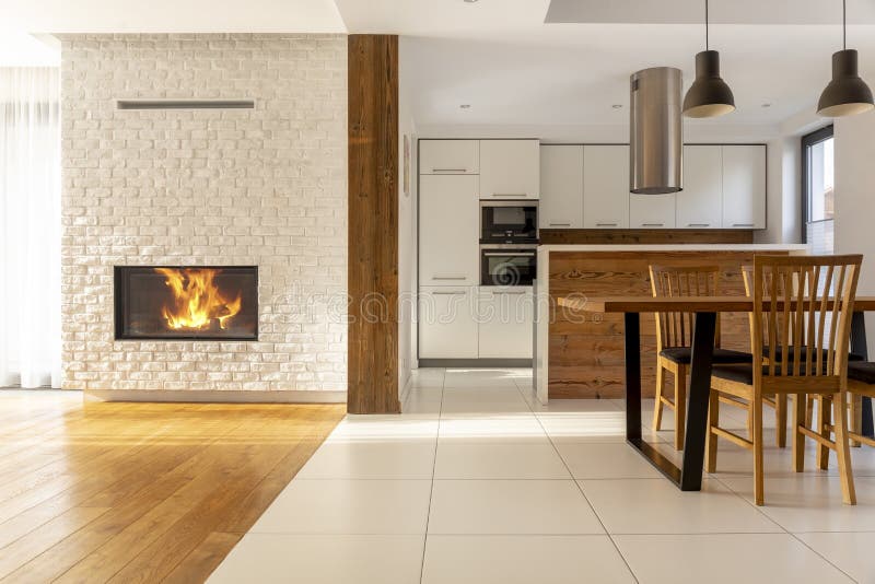 Camino nell'interno bianco spazioso della casa con le sedie di legno a immagini stock