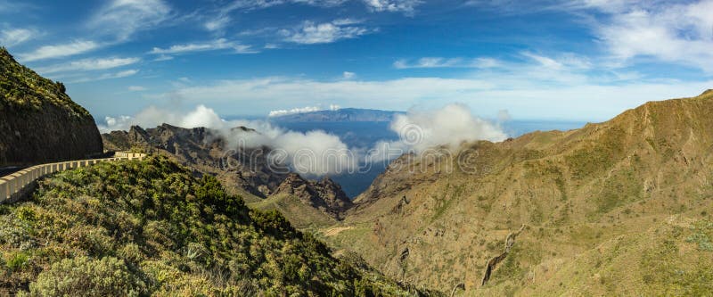 Camino serpentino y vista que sorprende del cielo azul con las nubes mullidas hermosas, isla del La Gomera, paisaje de la montaña fotos de archivo libres de regalías Camino serpentino y vista que sorprende del cielo azul con las nubes mullidas hermosas, isla del La Gomera, paisaje de la montaña fotos de archivo libres de regalías
