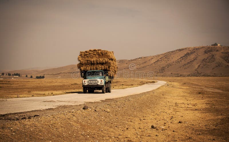 Camion avec de la paille sur la route photos stock