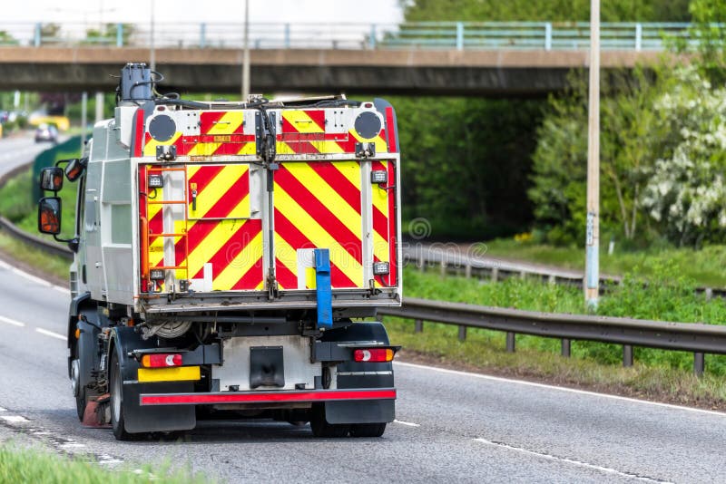 Camion del camion dell'autocisterna di manutenzione delle strade sull'autostrada del Regno Unito nel moto veloce fotografia stock Camion del camion dell'autocisterna di manutenzione delle strade sull'autostrada del Regno Unito nel moto veloce fotografia stock