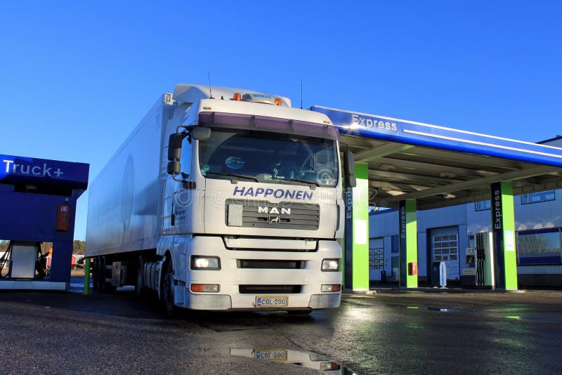 Camion et remorque de l'homme blanc 18,480 à un poste d'essence photographie stock Camion et remorque de l'homme blanc 18,480 à un poste d'essence photographie stock