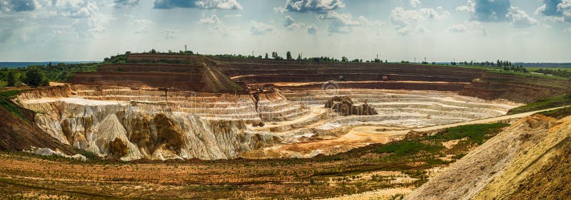 Camion à benne basculante de chargement d'excavatrice avec le kaolin cru dans l'exploitation à ciel ouvert de kaolin photo libre de droits Camion à benne basculante de chargement d'excavatrice avec le kaolin cru dans l'exploitation à ciel ouvert de kaolin photo libre de droits