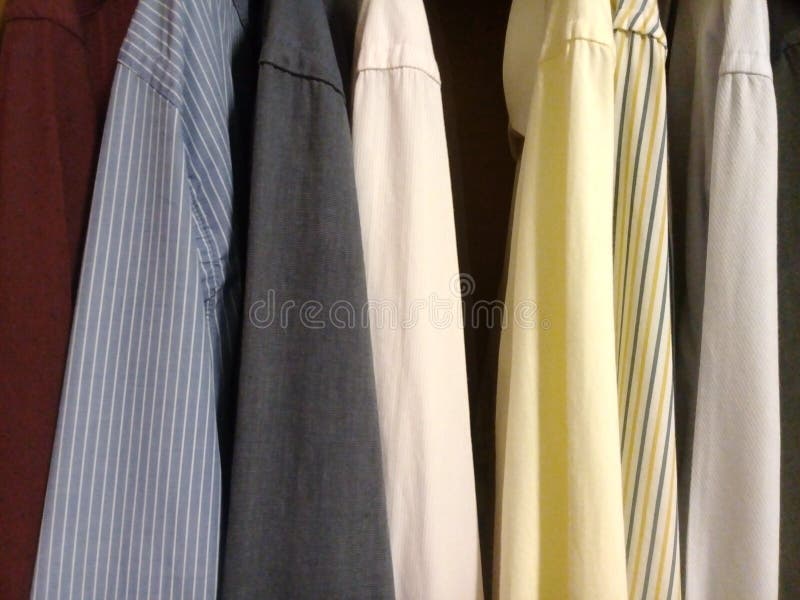 Camisas de vestido no armário - cores fotografia de stock royalty free Camisas de vestido no armário - cores fotografia de stock royalty free