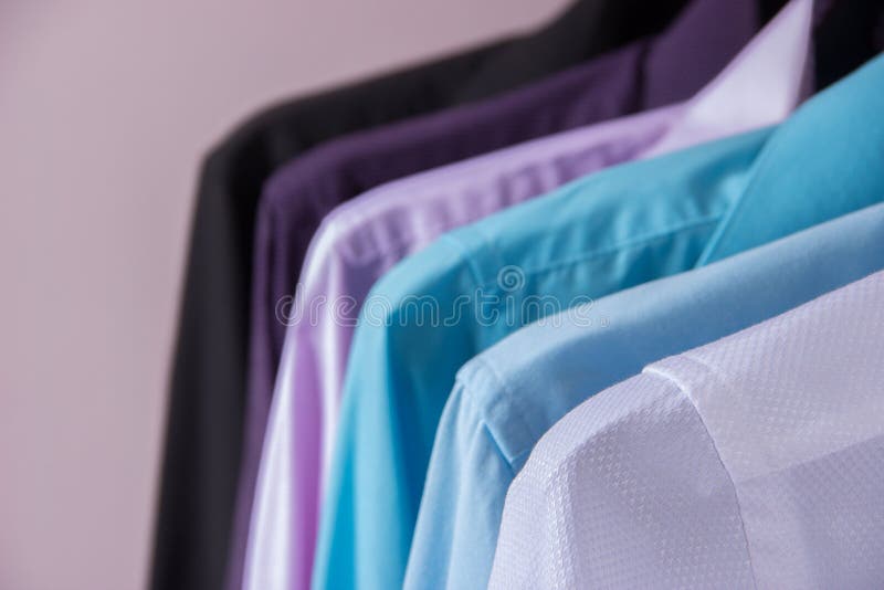 Camisas do ` s dos homens coloridos que penduram em ganchos foto de stock Camisas do ` s dos homens coloridos que penduram em ganchos foto de stock