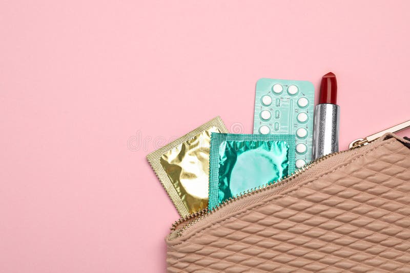 Camisinhas, pílulas anticoncepcionais e batom no fundo, vista superior com espaço para texto Sexo seguro