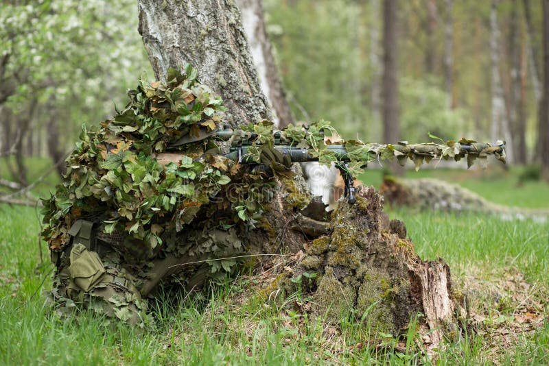 Camouflaged sniper lying in forest and aiming through his scope Stock Photo  by ©Nesterenko_Max 89112398