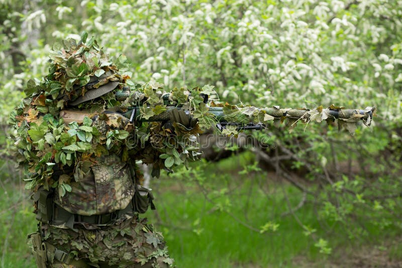 Camouflaged sniper lying in forest and aiming through his scope Stock Photo  by ©Nesterenko_Max 89112398