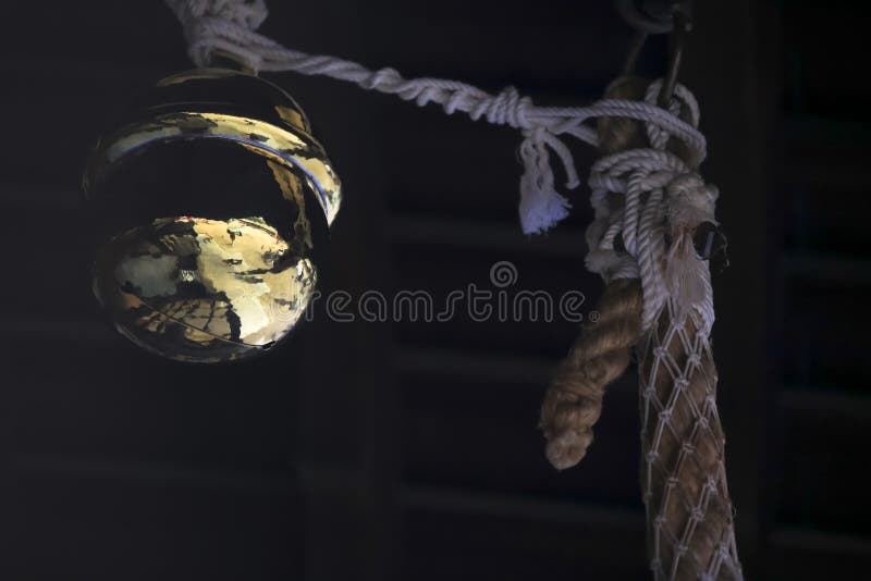 Campana que desea de oro del templo japonés tradicional en cuerda con la reflexión brillante foto de archivo Campana que desea de oro del templo japonés tradicional en cuerda con la reflexión brillante foto de archivo
