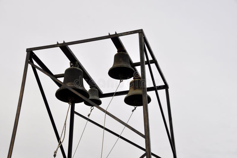 Campane di chiesa sui piloni del metallo contro un cielo senza nuvole fotografia stock libera da diritti Campane di chiesa sui piloni del metallo contro un cielo senza nuvole fotografia stock libera da diritti