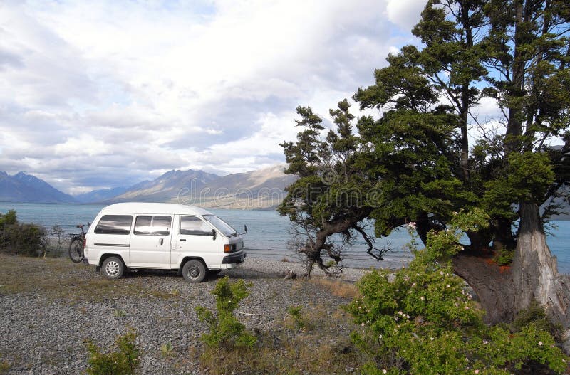 Camper van travel, camping. Caravan camping on lake shore with mountain scenery view. Camper van scenic independent travel in the New Zealand stock photo Camper van travel, camping. Caravan camping on lake shore with mountain scenery view. Camper van scenic independent travel in the New Zealand stock photo