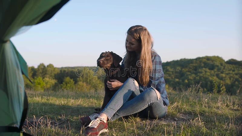 camping Gelukkige vrouw die met hond in aard reizen