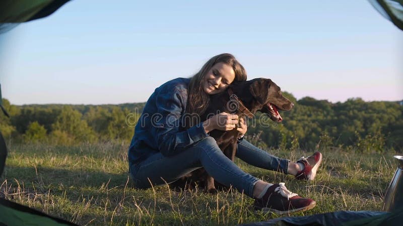 camping Gelukkige vrouw die met hond in aard reizen