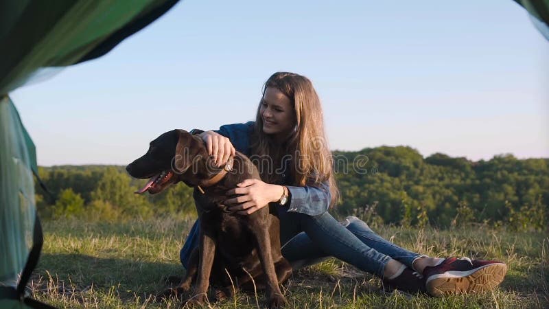 camping Gelukkige vrouw die met hond in aard reizen