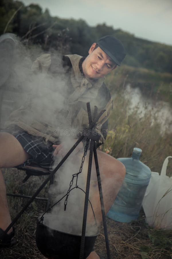 Camping outdoors leisure activity hiking happy people cooking on camp fire outdoors stock image Camping outdoors leisure activity hiking happy people cooking on camp fire outdoors stock image