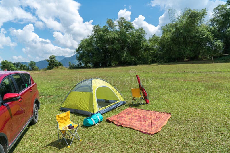 Camping Site on Grass Field with Tent and Car beside Tent. Leisure