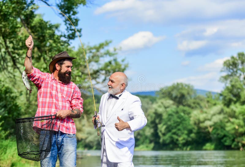 Camping sur le rivage hobby à poisson volant pêche à la retraite père à la retraite et fils barbu à maturité heureux. Camping sur le rivage hobby à poisson volant pêche à la retraite père à la retraite et fils barbu à maturité amitié joyeuse des pêcheurs Concept de capture et de pêche Deux amis qui pêchent ensemble
