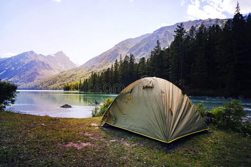 Camping tent in campground at national park. Tourists camped in the woods on the shore of the lake on the hillside. View of tent