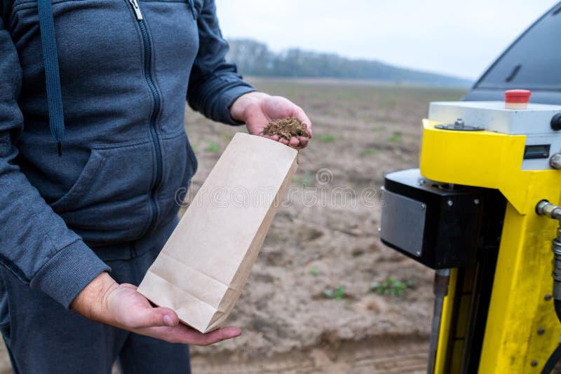 Campionamento del suolo Un impiegato dell'ingegnere di un laboratorio di ricerca imballa un campione del suolo in un pacchetto di