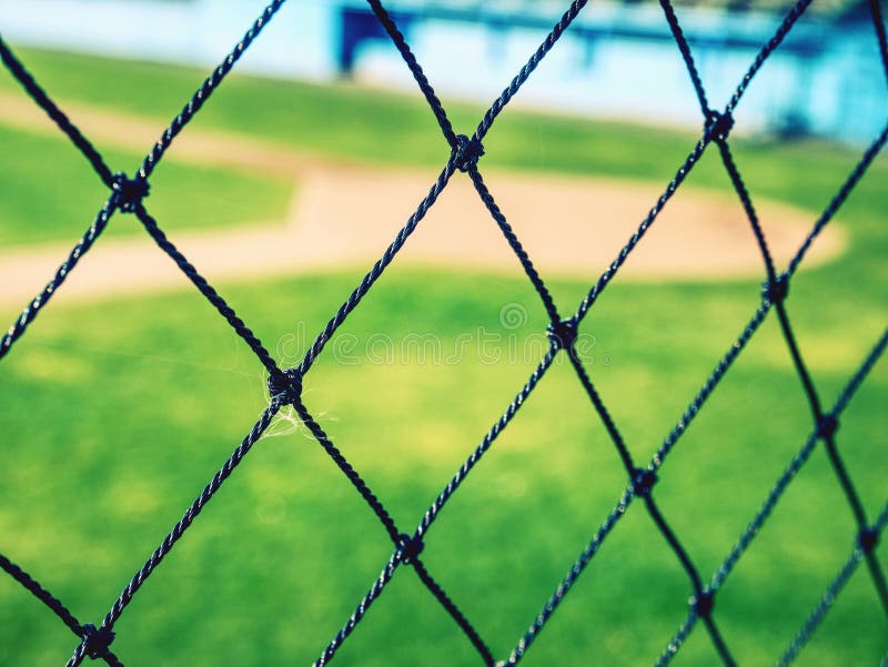 Campo de basebol da juventude visto da rede de tr?s fotos de stock royalty free Campo de basebol da juventude visto da rede de tr?s fotos de stock royalty free