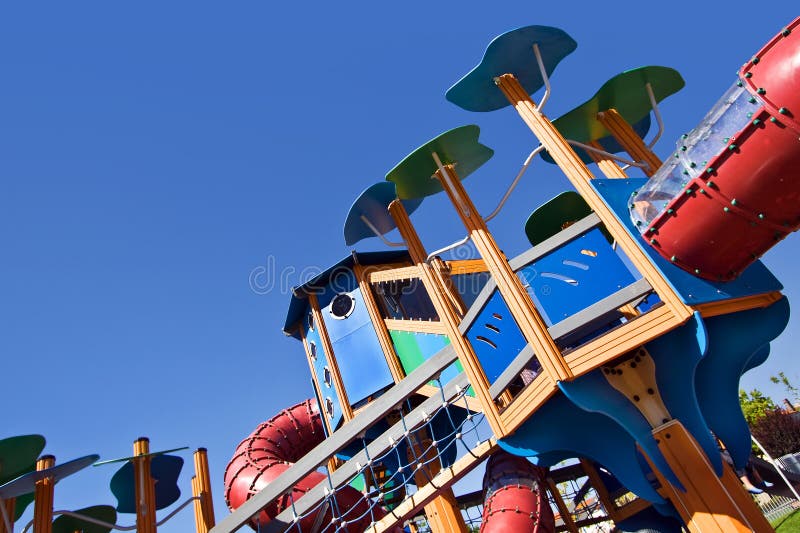 A perspective view of an empty and colourful playground over a clean blue sky. A perspective view of an empty and colourful playground over a clean blue sky