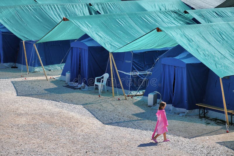 Campo de la tienda de los refugiados del terremoto con caminar solo del niño