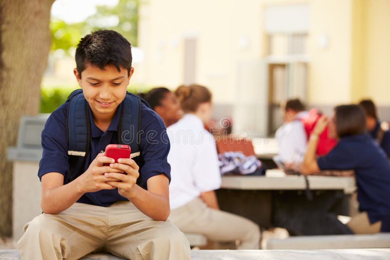 Campus masculin d'école d'Using Phone On d'étudiant de lycée images libres de droits Campus masculin d'école d'Using Phone On d'étudiant de lycée images libres de droits