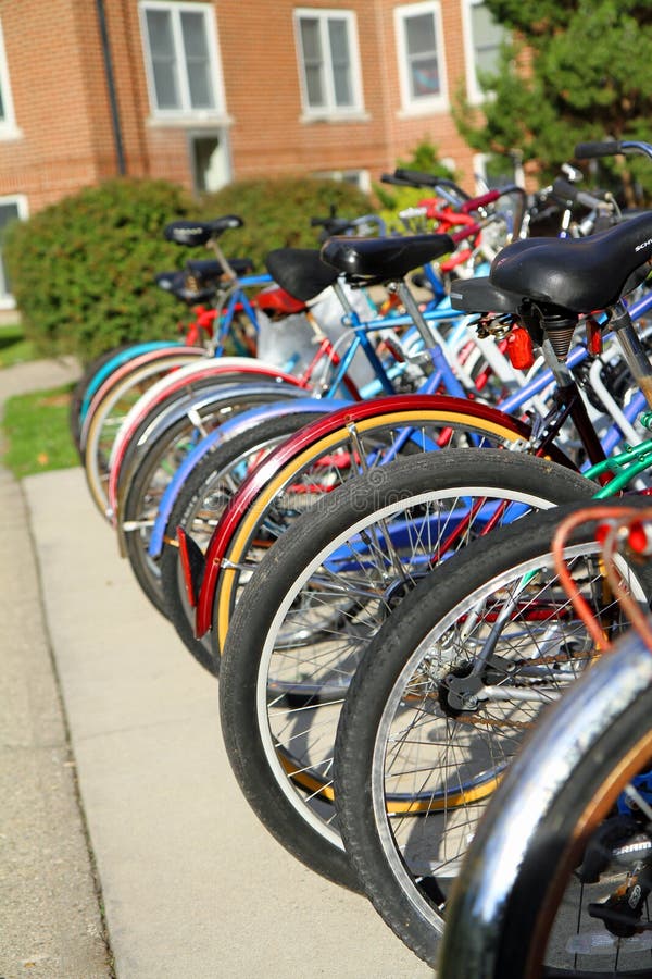 Bicycles stored on a bike rack outside a college dorm building. Image of pollution free way of transportation. Bicycles stored on a bike rack outside a college dorm building. Image of pollution free way of transportation.