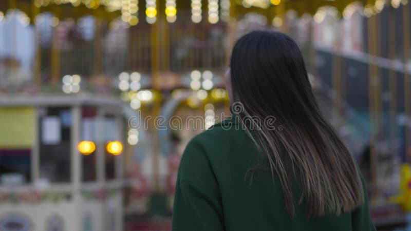 Caméra suivant la jolie jeune femme marche du caucase les carrousels des enfants Fille mignonne en ce qui concerne la caméra, sou