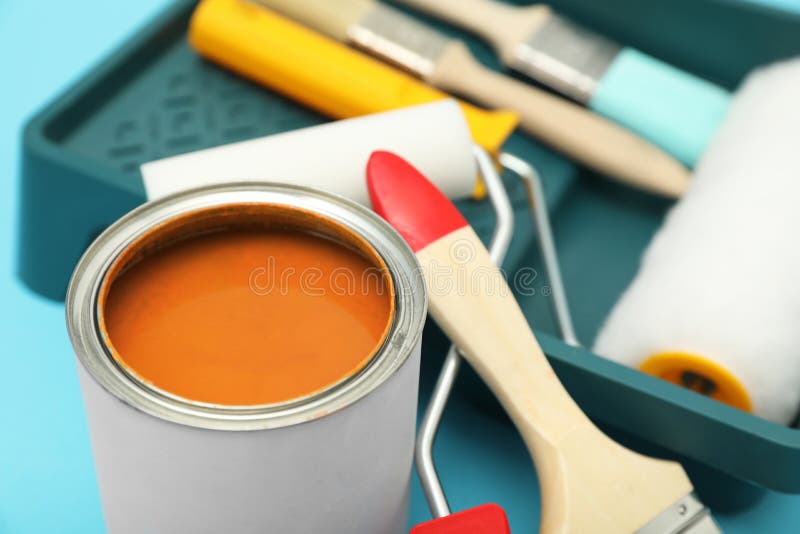Can of Orange Paint, Brushes, Rollers and Container on Turquoise