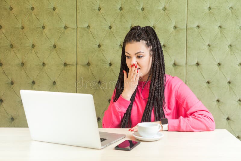 Can`t believe! Portrait of emotional shocked young woman with black dreadlocks hairstyle are sitting in cafe, reading news with royalty free stock photo Can`t believe! Portrait of emotional shocked young woman with black dreadlocks hairstyle are sitting in cafe, reading news with royalty free stock photo