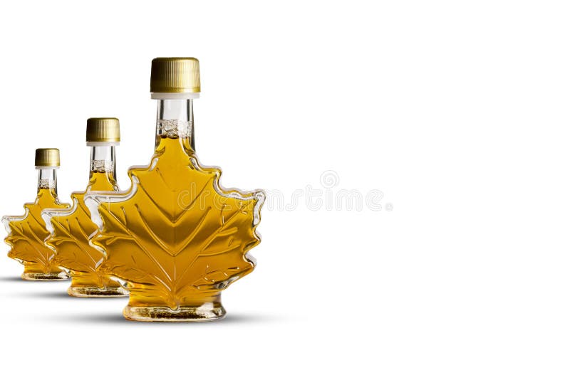 Canadese ahornstroop in drie transparante flessen met bladvorm die op witte achtergrond wordt geïsoleerd royalty-vrije stock foto Canadese ahornstroop in drie transparante flessen met bladvorm die op witte achtergrond wordt geïsoleerd royalty-vrije stock foto
