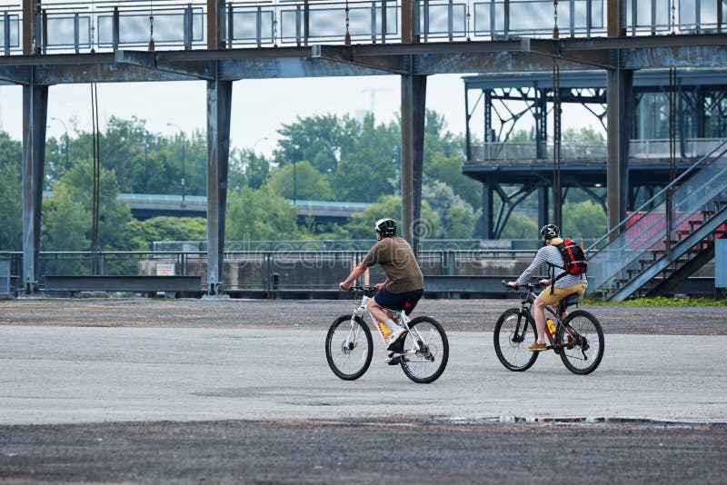 Canadian couple riding their bikes in old port, Montreal, Quebec, Canada royalty free stock photos Canadian couple riding their bikes in old port, Montreal, Quebec, Canada royalty free stock photos