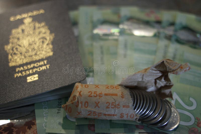 Canadian passport on twenty dollar bills and next to canadian coins. Theme of travel or immigration royalty free stock photo Canadian passport on twenty dollar bills and next to canadian coins. Theme of travel or immigration royalty free stock photo