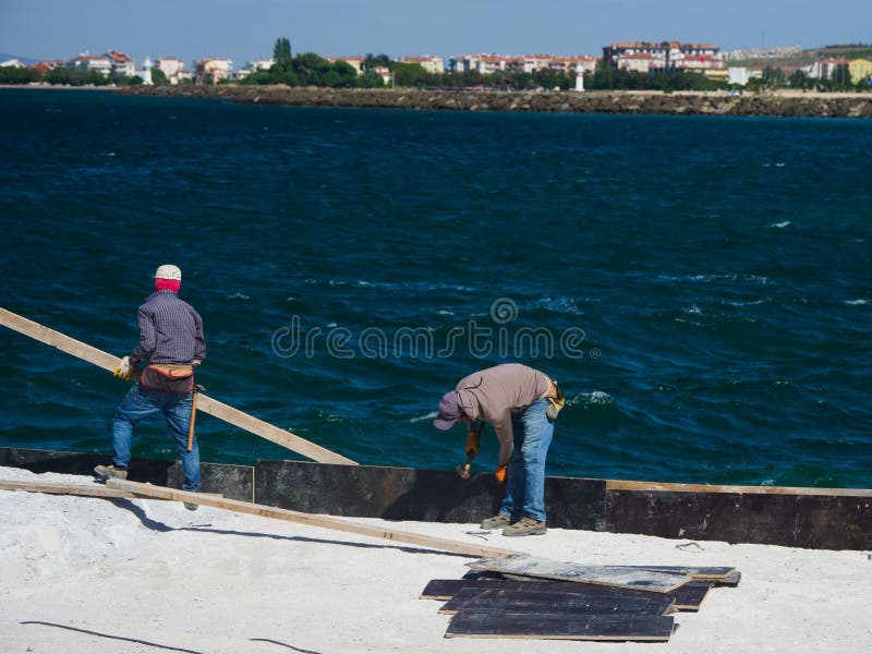 Canakkale, Turkey - October 05, 2018: Unidentified workers working at the harbour for a ferry crossing Dardanelles Strait in Canakkale, Turkey. Canakkale, Turkey - October 05, 2018: Unidentified workers working at the harbour for a ferry crossing Dardanelles Strait in Canakkale, Turkey