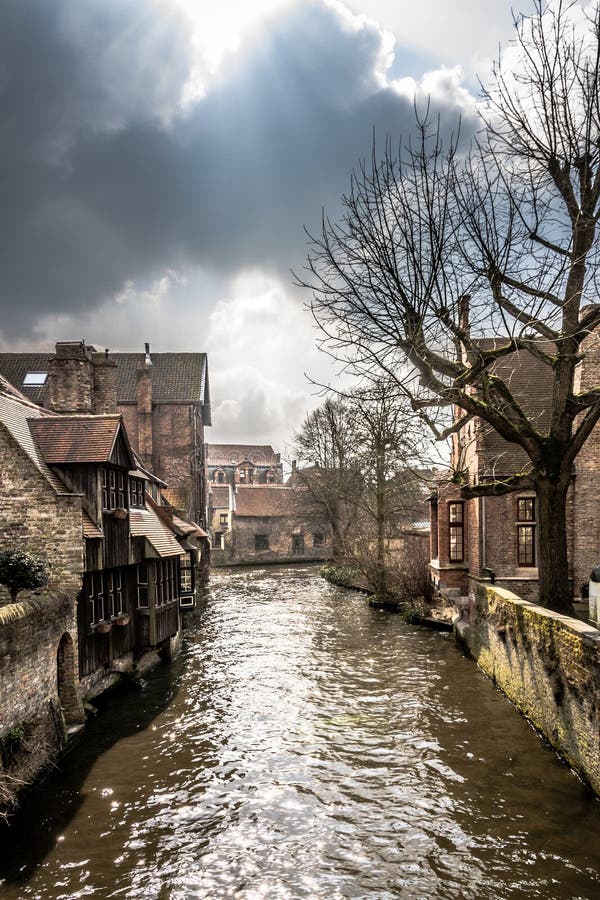 Canal vergonzoso que serpentea a través de Brujas medieval fotografía de archivo Canal vergonzoso que serpentea a través de Brujas medieval fotografía de archivo