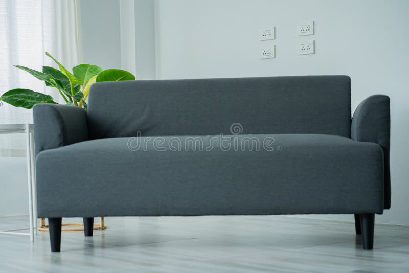 Canapea gri lângă peretele alb într-o sufragerie elegantă, spațiu modern pentru copii negative în interior deasupra fotografiei re royalty free stock photography