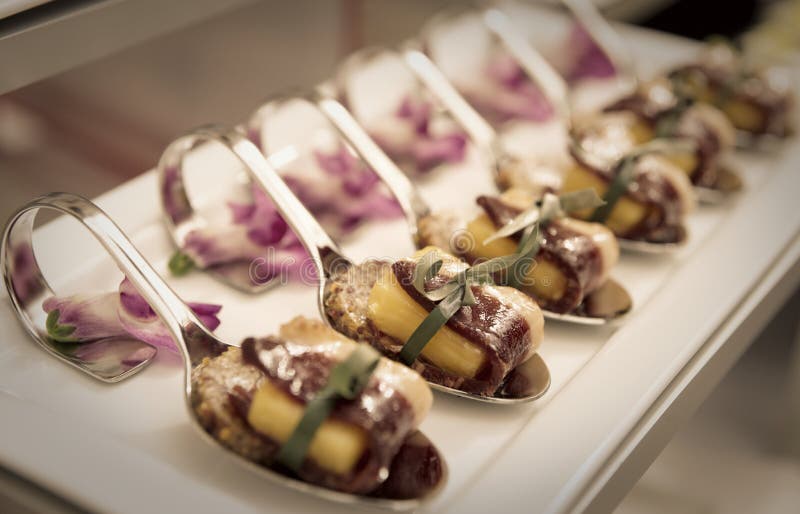Canapes con el jamón curado en la tabla de banquete fotografía de archivo Canapes con el jamón curado en la tabla de banquete fotografía de archivo