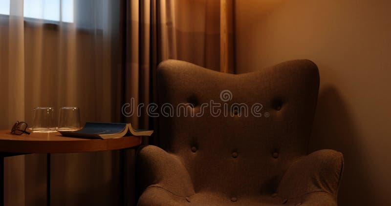 Canapé marron et table basse en bois avec livre et lunettes banque de vidéos
