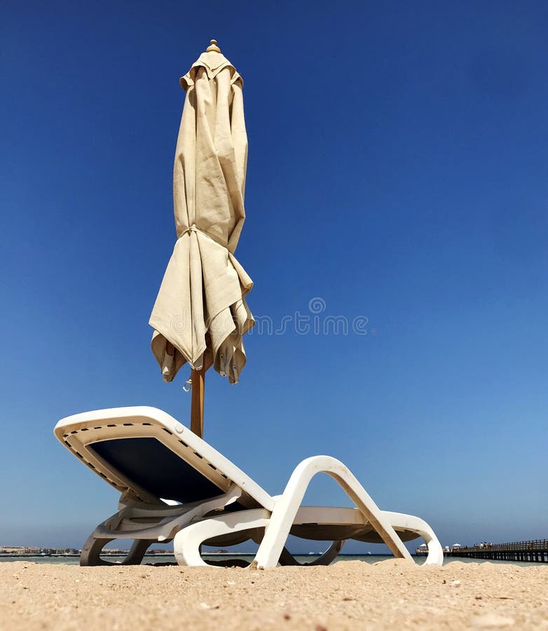 Canapé élégant dans à sable jaune pour exposer au soleil le lit pliant sur la plage en été sous le ciel ouvert photographie stock libre de droits Canapé élégant dans à sable jaune pour exposer au soleil le lit pliant sur la plage en été sous le ciel ouvert photographie stock libre de droits