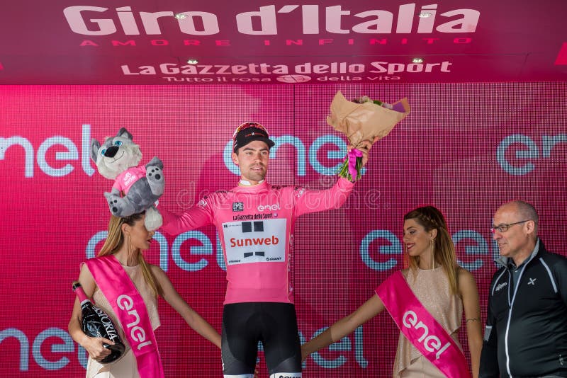 Canazei Italien Maj 24, 2017: Tom Doumulin i rosa ärmlös tröja av den bästa ryttaren, på podiet arkivbild Canazei Italien Maj 24, 2017: Tom Doumulin i rosa ärmlös tröja av den bästa ryttaren, på podiet arkivbild